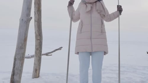 Woman Standing on a Swing in a Snowy Landscape
