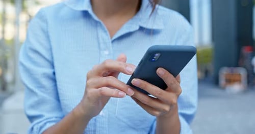Woman Using Smartphone on City Street Daytime