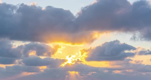Golden Sun Rays Shining Through Clouds at Sunset