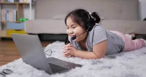 Child Lying on Rug Using Laptop at Home