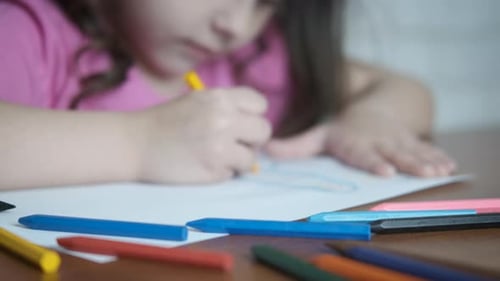 Little Girl Drawing on Paper with Crayons
