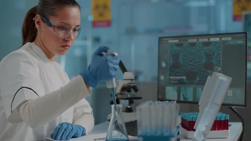 Female Scientist Pipetting Liquid in a Laboratory