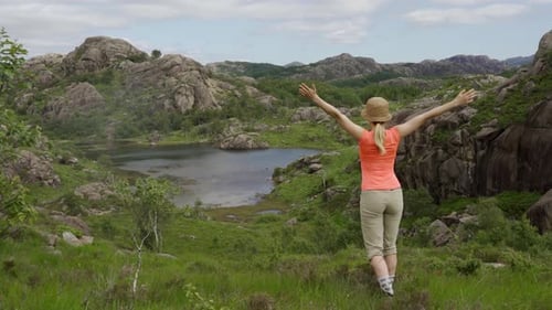 Hiker In Awe Over Tranquil Lake In Lush Landscape