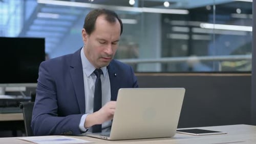 Businessman Coughing While Using Laptop in Office