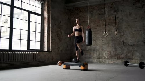Athletic Woman Doing Step Aerobics in Gym