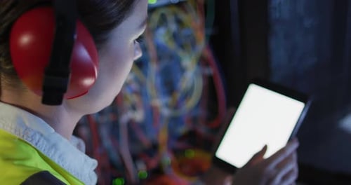 Kaukasische IT-Technikerin verwendet Tablet mit leerem Bildschirm zur Überprüfung des Computerservers