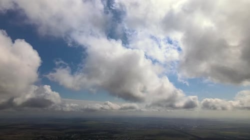 Aerial View at High Altitude of Earth Covered with Puffy Cumulus Clouds Forming Before Rainstorm