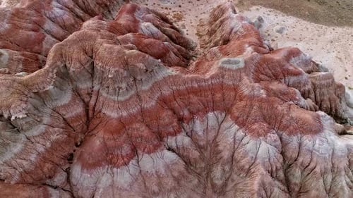 Flying over red desert hills rising into the air over the landscape