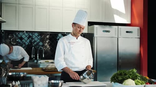 Professional restaurant kitchen: Chef whisking eggs in a bowl