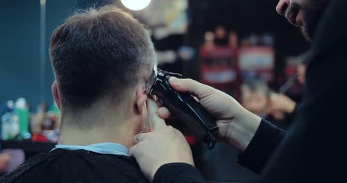 Barber Cutting Customer's Hair with Electric Trimmer