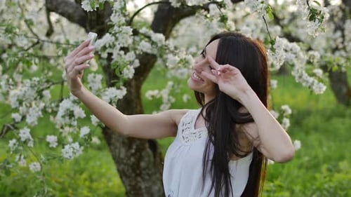 Attractive Woman Taking a Selfie in Blossom Orchard