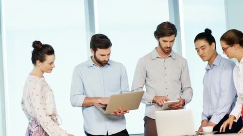 Diverse Team Collaborates on Technology in Bright Office