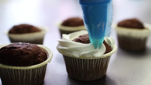 Schokoladen-Cupcake mit weißer Sahne verzieren