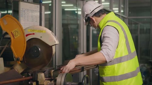 les travailleurs portent des uniformes, les casques de sécurité utilisent un ruban à mesurer pour mesurer le tuyau d'acier avant de le couper