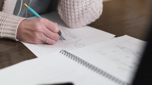 Fashion Designer Drawing Sketches at Workplace