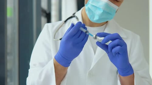 Medical Professional Drawing Liquid into Syringe