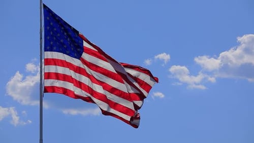 American Flag Waving Proudly Against Blue Sky