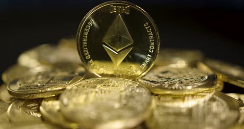 Echte goldene Münzen mit Ethereum-Logo auf schwarzem Hintergrund