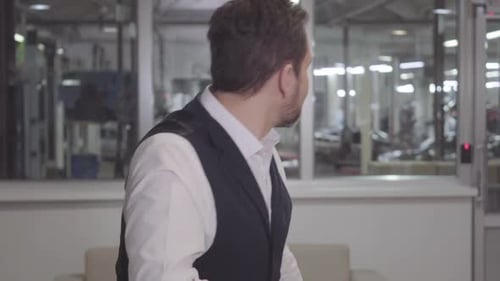 Portrait of Bearded Handsome Caucasian Man Drinking Coffee and Looking Back at Repair Shop