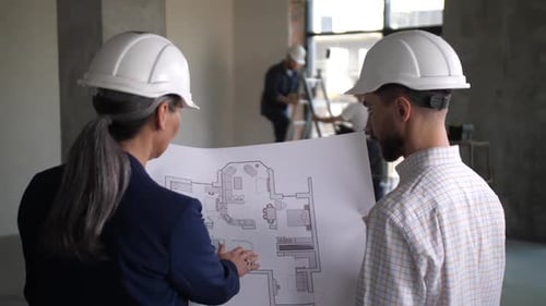 Architects Review Blueprints in Construction Office