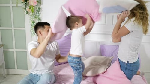 Happy Family Pillow Fight on Bed