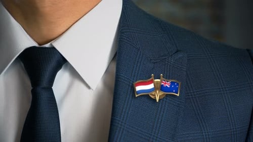 Man in Suit with Netherlands and New Zealand Flags