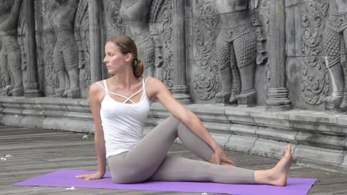 Woman Practicing Yoga During Yoga Retreat in Asia Bali Meditation Relaxation in Abandoned Temple