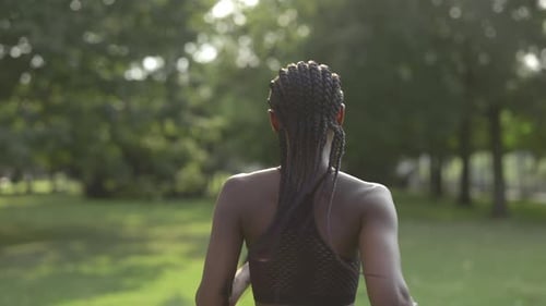 Back View of Woman with Afro Braids Jogging at City Park