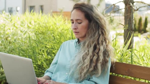 Beautiful Caucasian Woman Working on Laptop in Park