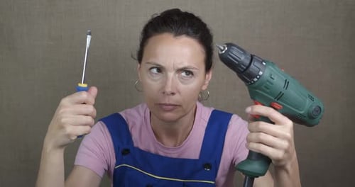 Woman worker with working drill.