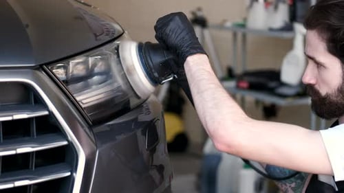 Man Polish a Car in a Garage