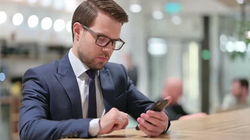 Attractive Businesswoman Using Smartphone at Work