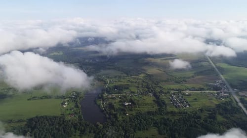 Very Slow and Smooth Flight Above the Clouds. Low Cumulus Cloud Cover. Below You Can See the Rural