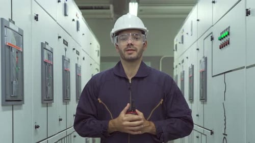 Engineer in Electrical Room Holding Walkie-Talkie