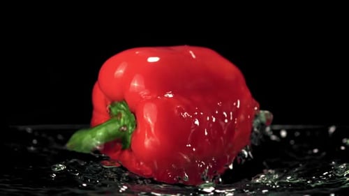 Red Pepper Splashing in Water on Black Background
