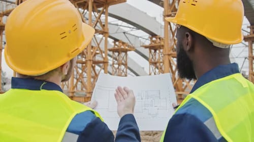 Engineers Reviewing Blueprint at Construction Site