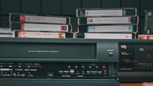 Hand operates vintage VHS player, close up shot