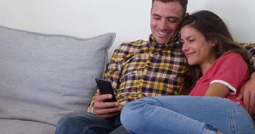 Couple Relaxing at Home Looking at Phone