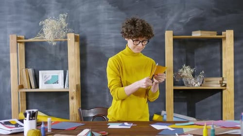 Woman Cuts Paper at Craft Table