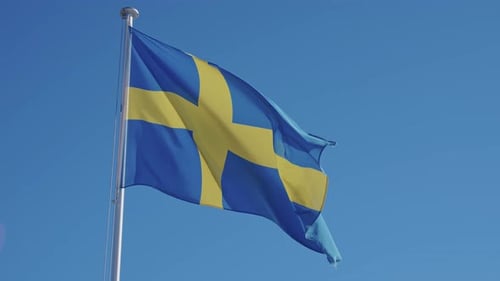 Swedish Flag Waving Proudly Against Blue Sky