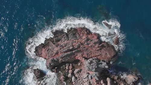 Ocean waves crash over rocky shore. Sea landscape with rocky coastline.