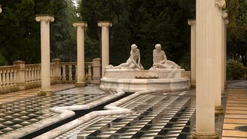 Ornate Fountain Surrounded by Columns and Statues