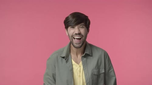 Man Laughing Expressively Against a Pink Background