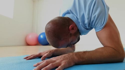 Man exercising on mat in the fitness studio 4k