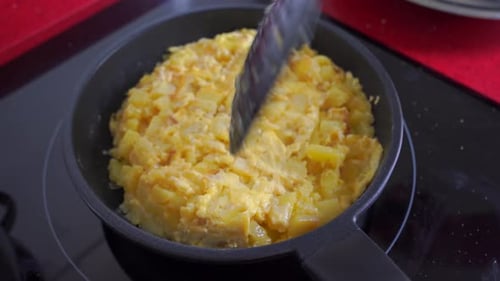 Frying Pan Omelet with Potatoes Cooking on Cooktop