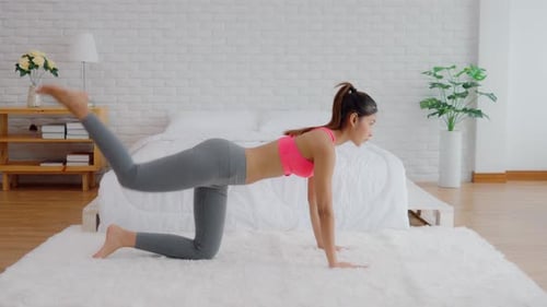 Young Woman Exercising Glutes on Rug Indoors
