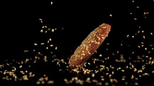 Super Slow Motion Oatmeal Cookie Falls on the Table with Sesame Seeds