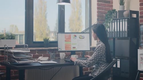 Woman Analyzing Business Data at Office Desk