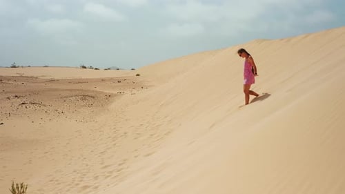 Child Walking Down a Sand Dune Barefoot