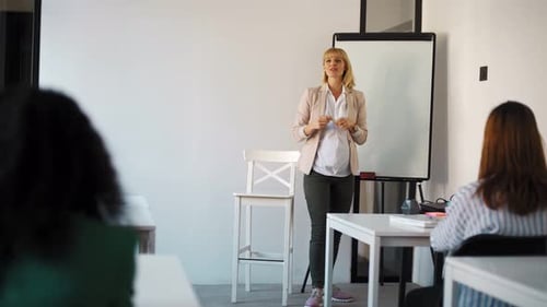 Blond pregnant teacher speaking at flip chart